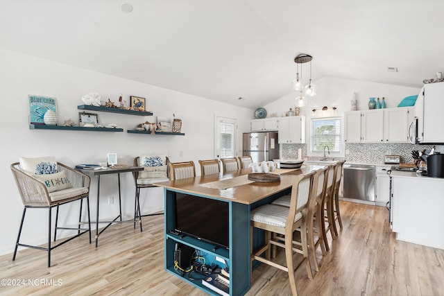 130 Crab St, Holden Beach, NC 28462 - dining area with light wood-style floors and vaulted ceiling