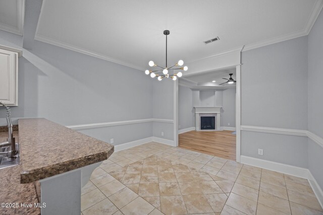 2324 Dovedale Dr Unit B, Greenville, NC 27834 - unfurnished dining area featuring crown molding, a chandelier, a fireplace, light tile patterned floors, and a ceiling fan