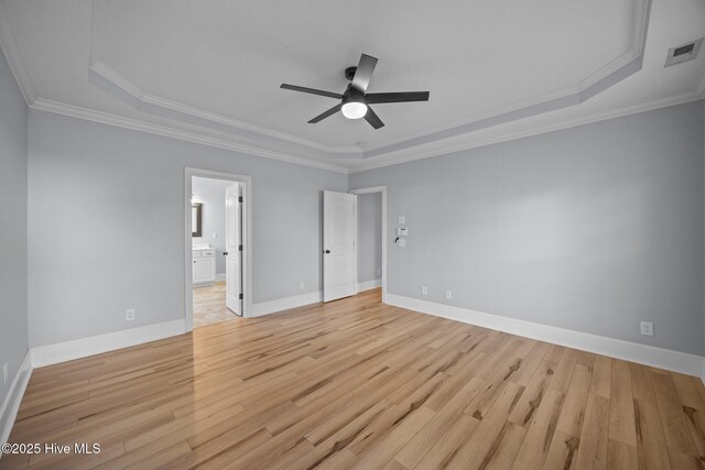 2324 Dovedale Dr Unit B, Greenville, NC 27834 - unfurnished bedroom featuring light wood-style floors, crown molding, a tray ceiling, connected bathroom, and ceiling fan
