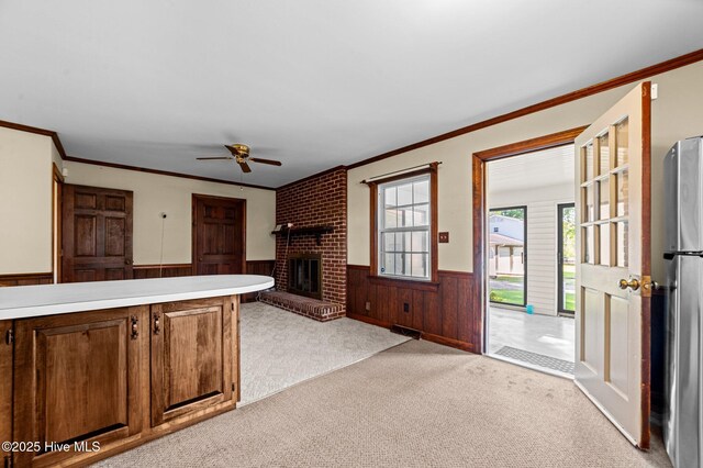 6715 Clarks Neck Rd, Washington, NC 27889 - unfurnished living room with a wainscoted wall, light carpet, crown molding, ceiling fan, and a fireplace