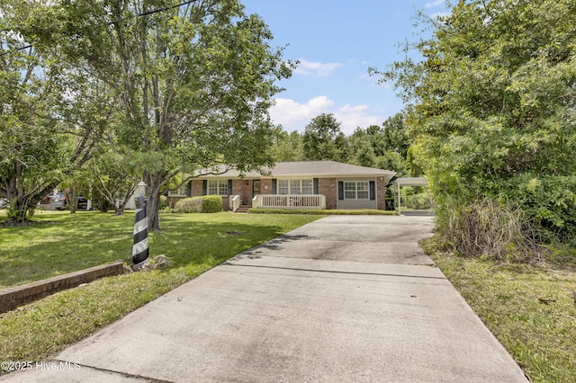 605 Mohican Trl, Wilmington, NC 28409 - ranch-style home featuring brick siding, driveway, covered porch, and a front lawn