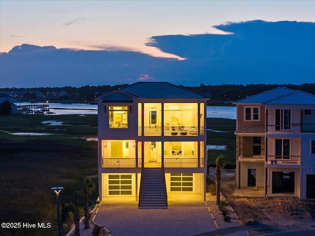47 Grande View Dr, Ocean Isle Beach, NC 28469 - view of front of property with a balcony, a garage, a water view, and driveway