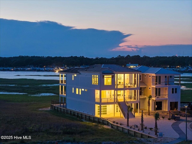 47 Grande View Dr, Ocean Isle Beach, NC 28469 - view of front facade with a balcony, a water view, stairs, and a metal roof