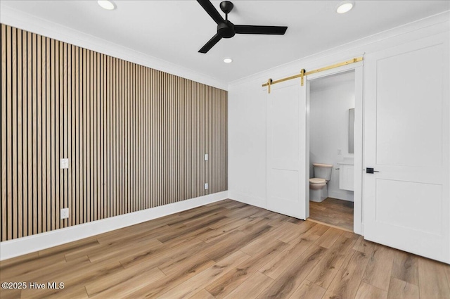 47 Grande View Dr, Ocean Isle Beach, NC 28469 - unfurnished bedroom with wood finished floors, ornamental molding, recessed lighting, ensuite bath, and a barn door