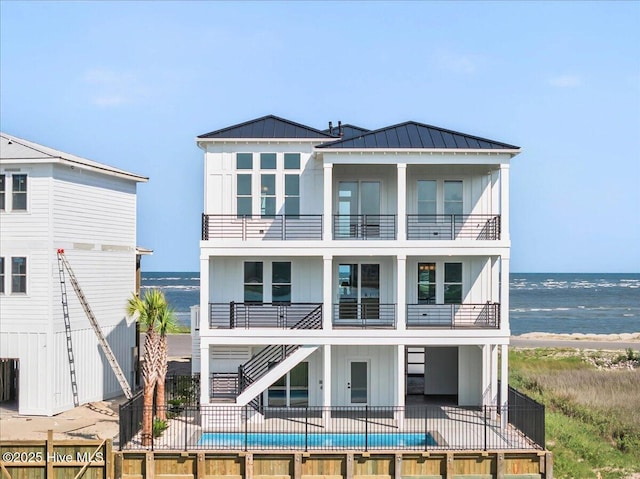 47 Grande View Dr, Ocean Isle Beach, NC 28469 - rear view of house with a balcony, board and batten siding, a water view, and a standing seam roof