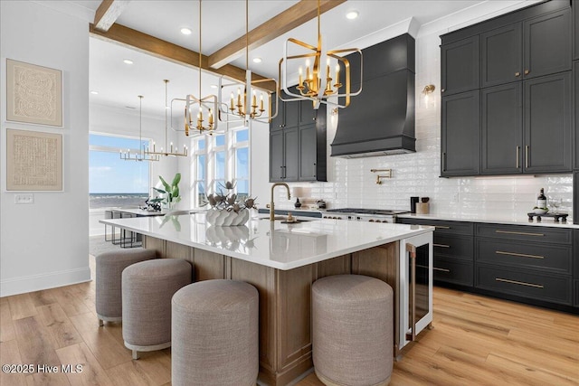 47 Grande View Dr, Ocean Isle Beach, NC 28469 - kitchen featuring a chandelier, light wood-style floors, a kitchen bar, beverage cooler, and beam ceiling