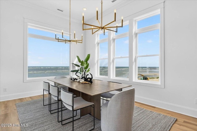 47 Grande View Dr, Ocean Isle Beach, NC 28469 - dining area featuring a chandelier, wood finished floors, and a water view