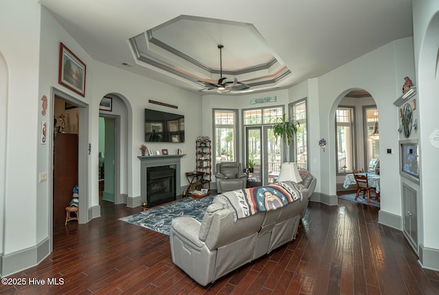 6601 Annesbrook Pl, Ocean Isle Beach, NC 28469 - living room with a glass covered fireplace, ceiling fan, arched walkways, and dark wood-type flooring