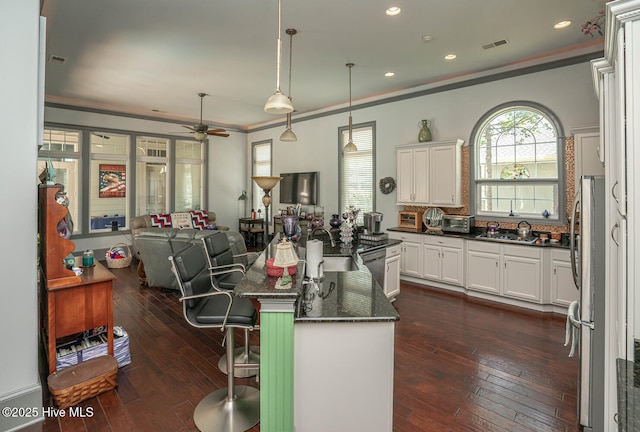 6601 Annesbrook Pl, Ocean Isle Beach, NC 28469 - kitchen with stainless steel appliances, crown molding, white cabinetry, a kitchen bar, and open floor plan