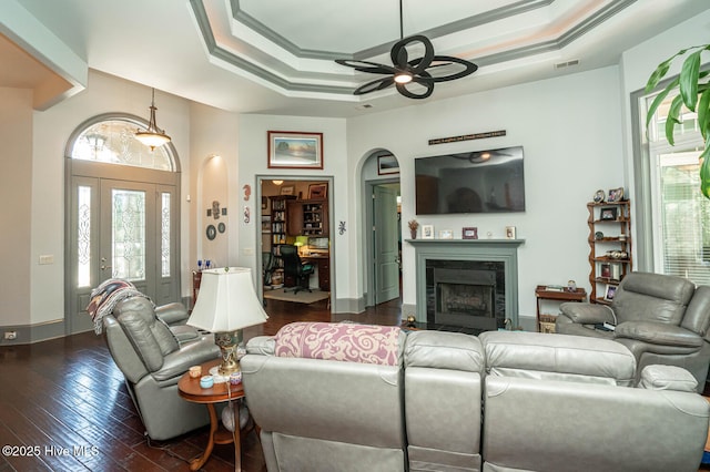 6601 Annesbrook Pl, Ocean Isle Beach, NC 28469 - living room with ceiling fan, a fireplace, a tray ceiling, dark wood-style flooring, and crown molding