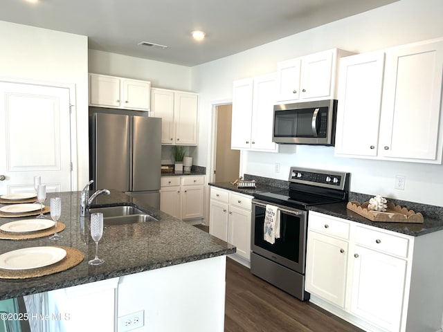 109 Mesa Ln, Holly Ridge, NC 28445 - kitchen featuring stainless steel appliances, white cabinetry, dark wood-style floors, and dark stone counters