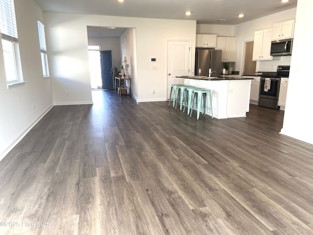 109 Mesa Ln, Holly Ridge, NC 28445 - kitchen featuring stainless steel appliances, dark countertops, white cabinets, recessed lighting, and a kitchen island with sink