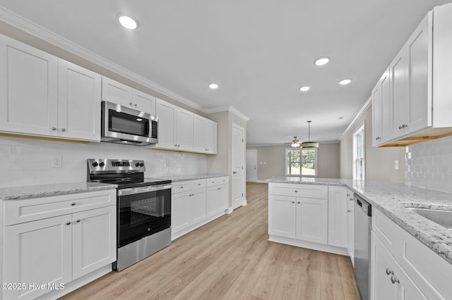 92 Hampton Way, Snow Hill, NC 28580 - kitchen with appliances with stainless steel finishes, crown molding, a peninsula, white cabinets, and recessed lighting