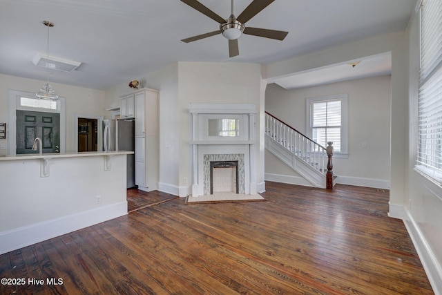 305 Mcrae St, Wilmington, NC 28401 - unfurnished living room featuring dark wood finished floors, a ceiling fan, stairs, and a premium fireplace