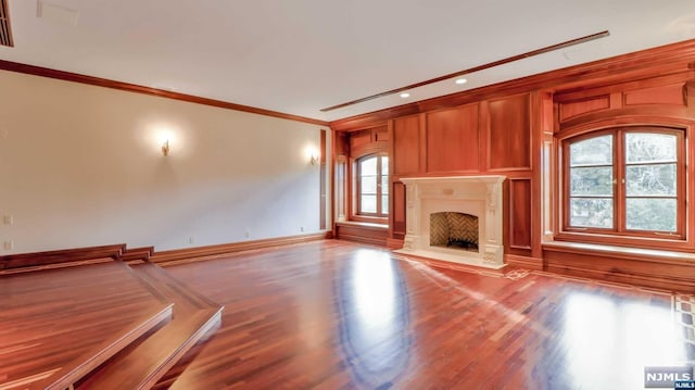 unfurnished living room with crown molding and wood-type flooring