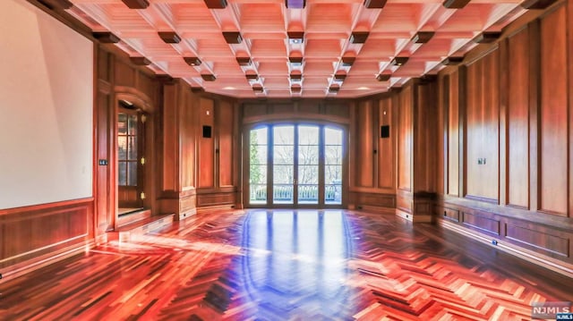 unfurnished room featuring beam ceiling, wooden walls, coffered ceiling, and parquet flooring