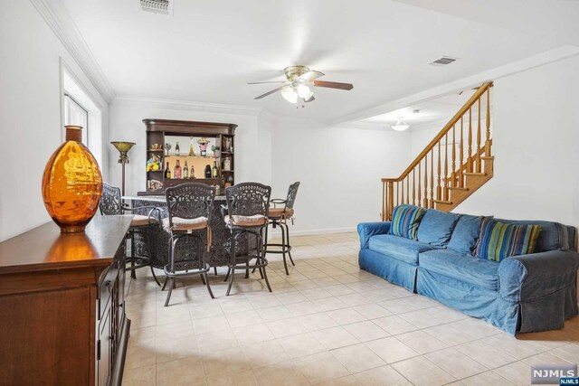 living room with bar, ceiling fan, and ornamental molding