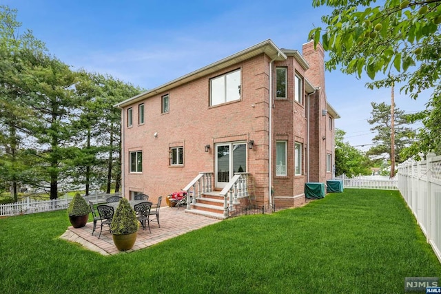 rear view of house with a lawn and a patio area