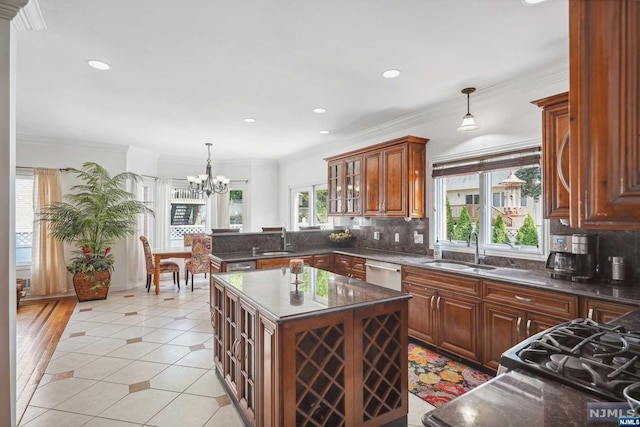 kitchen with pendant lighting, backsplash, a kitchen island, and sink