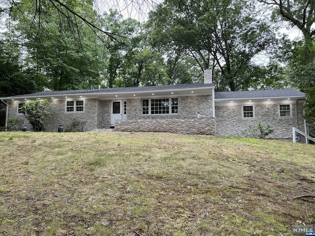 rear view of house featuring a lawn