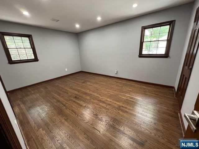 spare room with dark hardwood / wood-style floors and a wealth of natural light