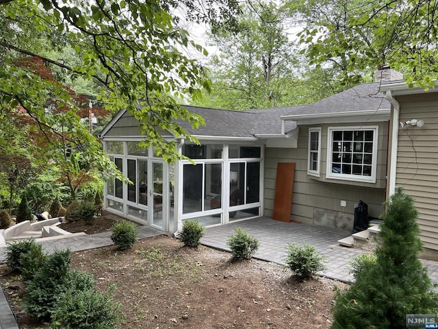 rear view of property with a patio area and a sunroom