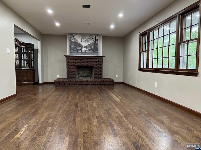 unfurnished living room with a fireplace and dark wood-type flooring