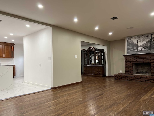 unfurnished living room featuring dark hardwood / wood-style flooring and a fireplace