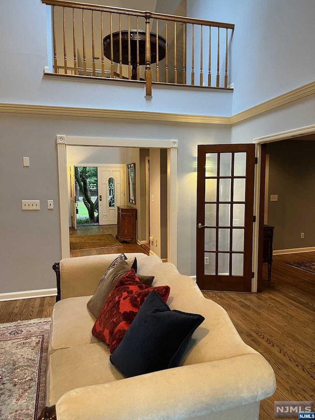 bedroom featuring hardwood / wood-style floors, a towering ceiling, and french doors