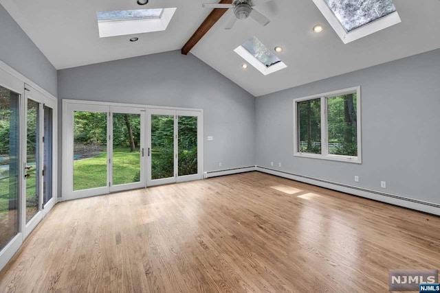 interior space featuring beam ceiling, ceiling fan, light hardwood / wood-style flooring, and a healthy amount of sunlight