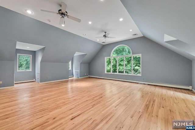 bonus room with light hardwood / wood-style floors, baseboard heating, a wealth of natural light, and lofted ceiling