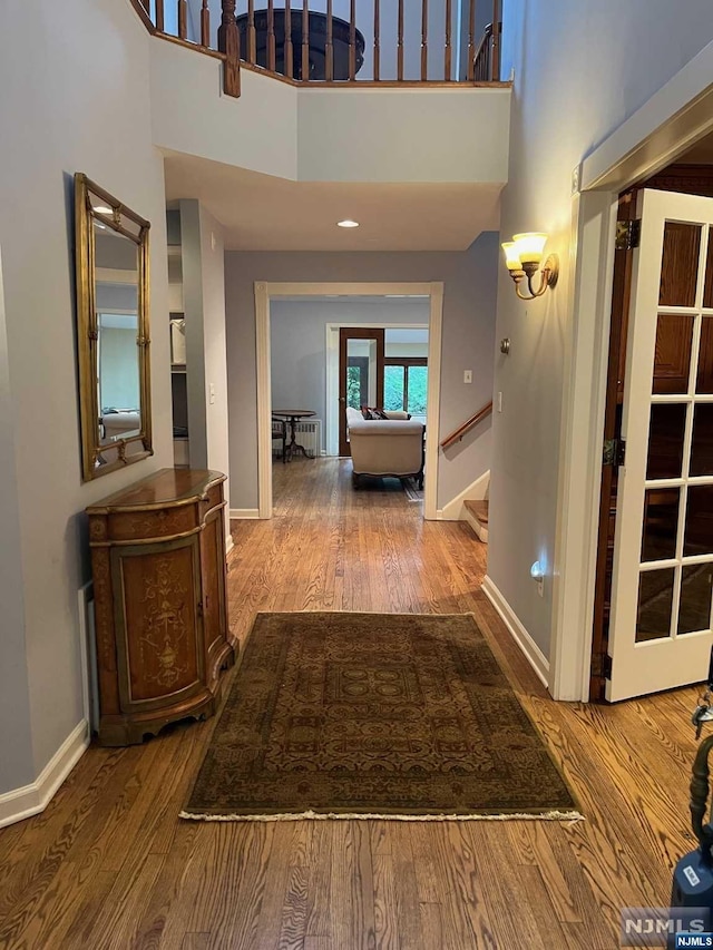 hallway featuring hardwood / wood-style floors and a high ceiling