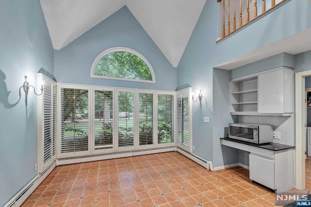 kitchen featuring light tile patterned floors, white cabinetry, high vaulted ceiling, and baseboard heating