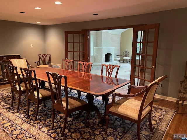 dining area with a fireplace, french doors, and dark hardwood / wood-style floors