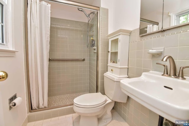 bathroom featuring sink, tile patterned flooring, toilet, tile walls, and a shower with shower curtain