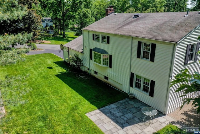 view of property exterior featuring a yard and a patio