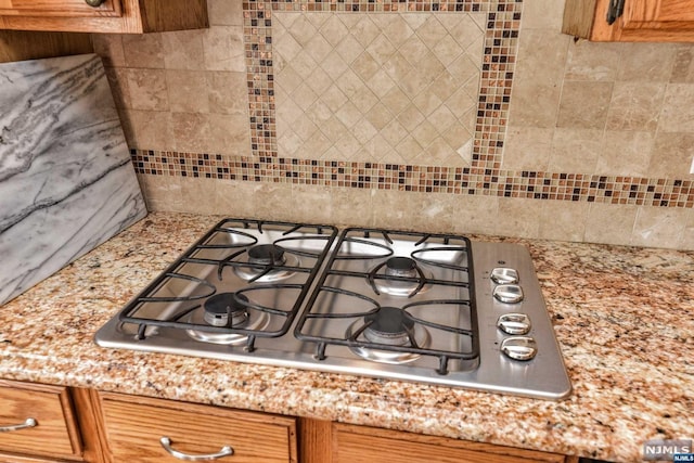 interior details with backsplash and stainless steel gas cooktop