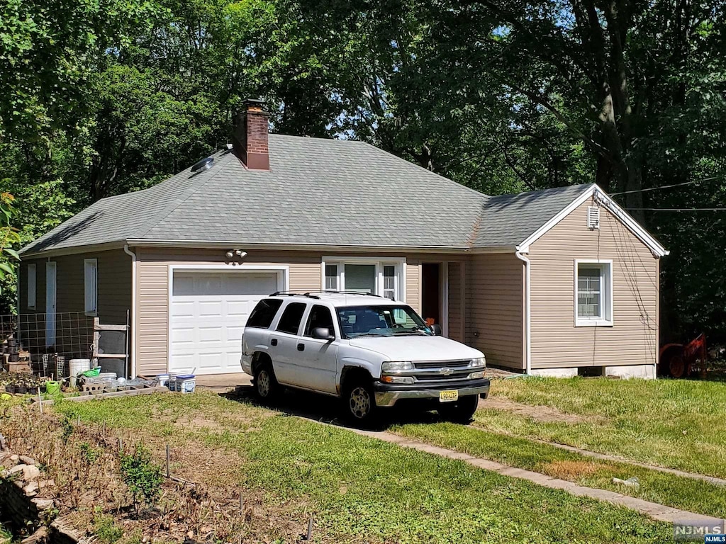 view of front of home featuring a garage and a front yard