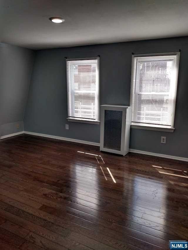 unfurnished room featuring dark hardwood / wood-style flooring and a wealth of natural light