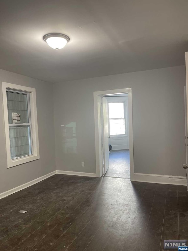 unfurnished room featuring dark wood-type flooring