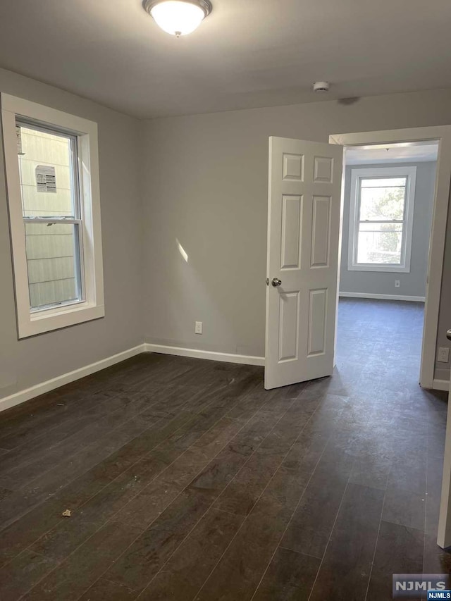 empty room with dark wood-type flooring