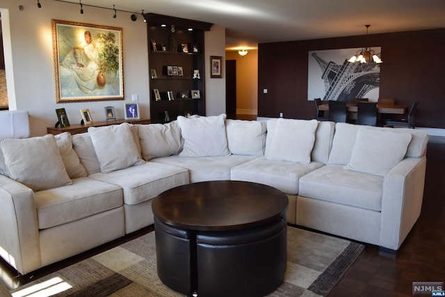 living room featuring dark wood-type flooring and a notable chandelier