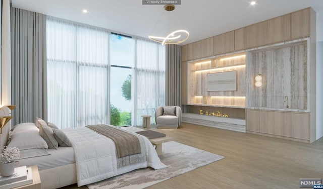 bedroom featuring a notable chandelier, multiple windows, and light hardwood / wood-style flooring