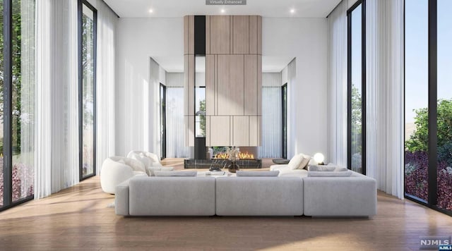 living room featuring a healthy amount of sunlight, light wood-type flooring, and a high ceiling