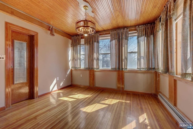 unfurnished sunroom with wood ceiling, baseboard heating, and a chandelier