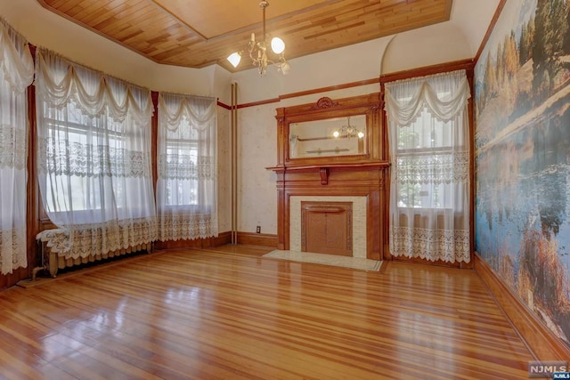 unfurnished living room with hardwood / wood-style floors, wood ceiling, and a notable chandelier