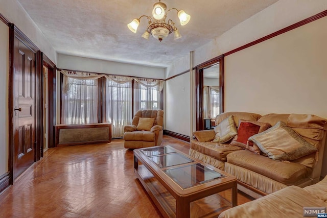 living room featuring parquet flooring, a textured ceiling, and a notable chandelier