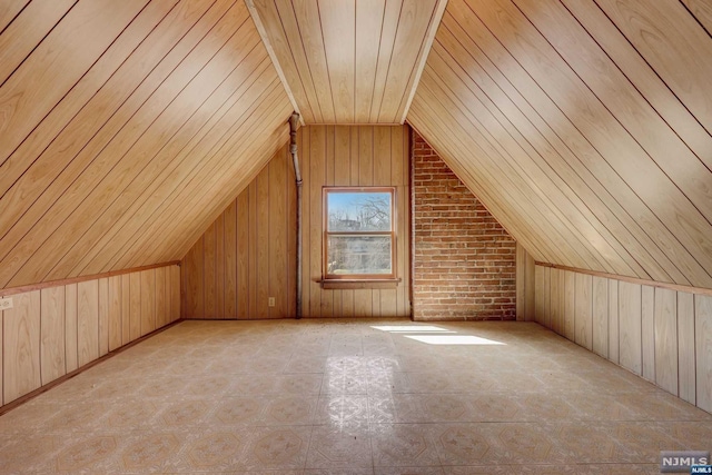 additional living space featuring wooden walls, brick wall, wooden ceiling, and vaulted ceiling