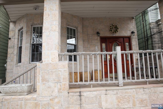 view of exterior entry featuring covered porch