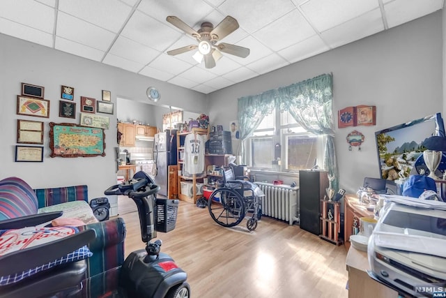 interior space featuring light wood-type flooring, ceiling fan, and a paneled ceiling